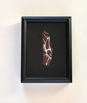 brown goose feather with white ink design on black background Miya Turnbull