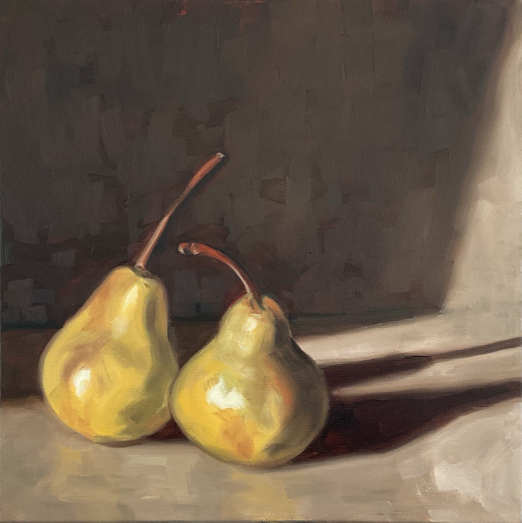 Two pears on a reflective surface with a dark background