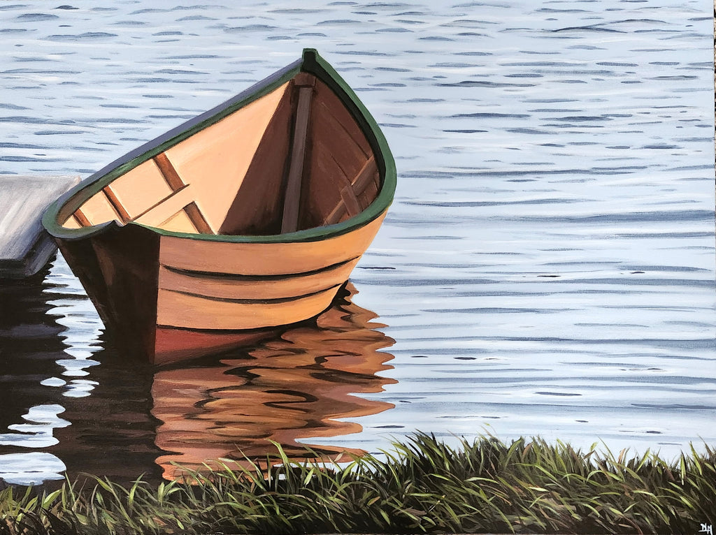 Wooden boat on calm water with grass at the edge