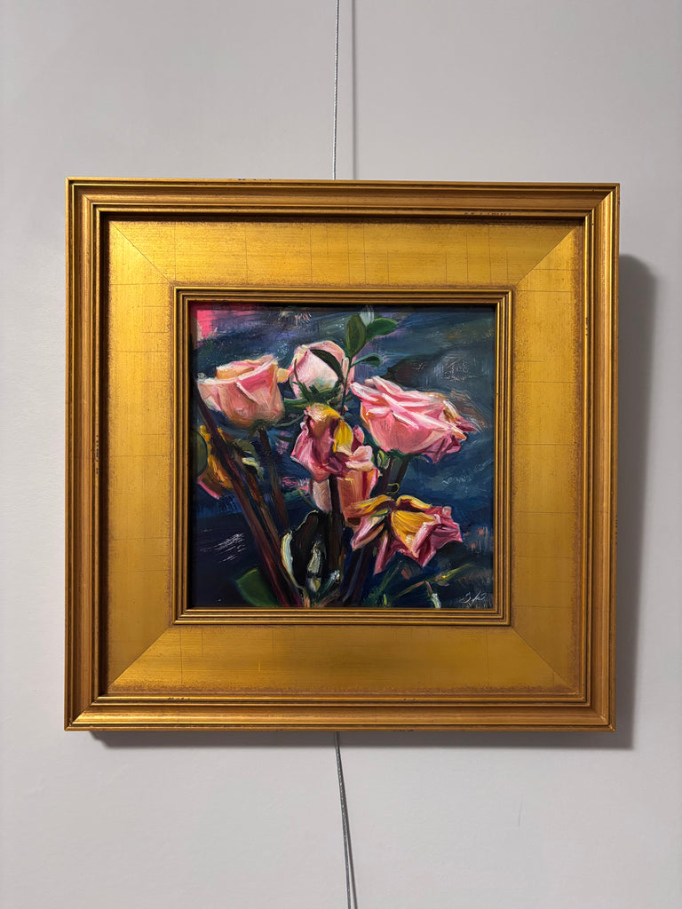 Framed painting of pink flowers on a white wall
