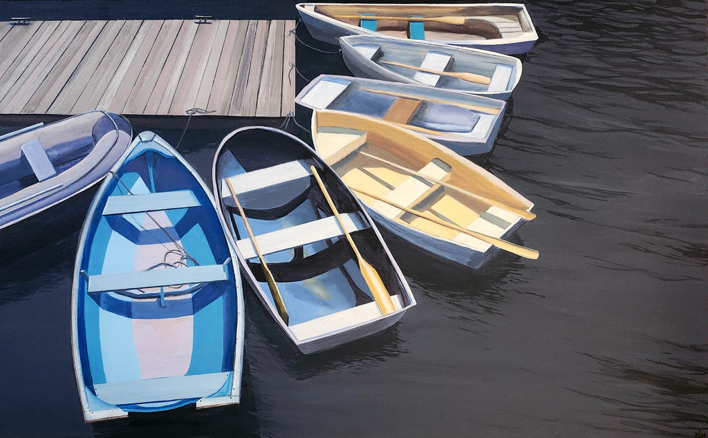 Rowboats docked at a wooden pier on a calm body of water
