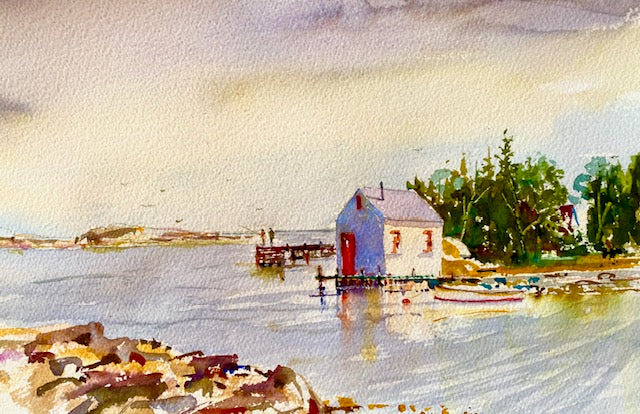 Watercolor painting of a small house by a body of water with trees in the background.