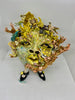 Colorful ceramic sculpture of a face with floral and natural elements on a white background