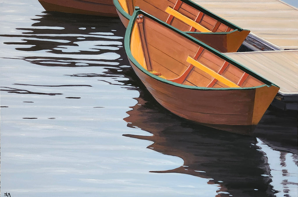 Two wooden rowboats on a dock with water reflection