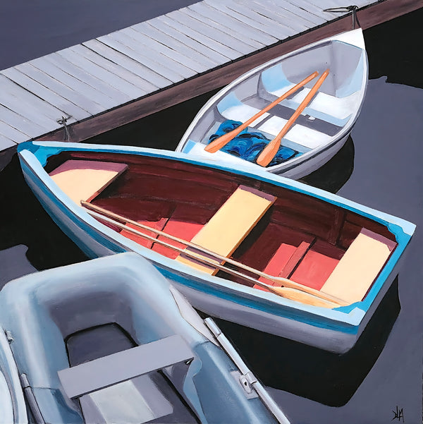 Two boats docked at a pier with one open and showing its interior.