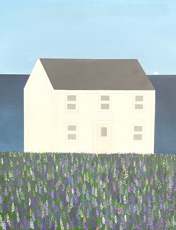 White house with a gray roof in a field of flowers under a blue sky