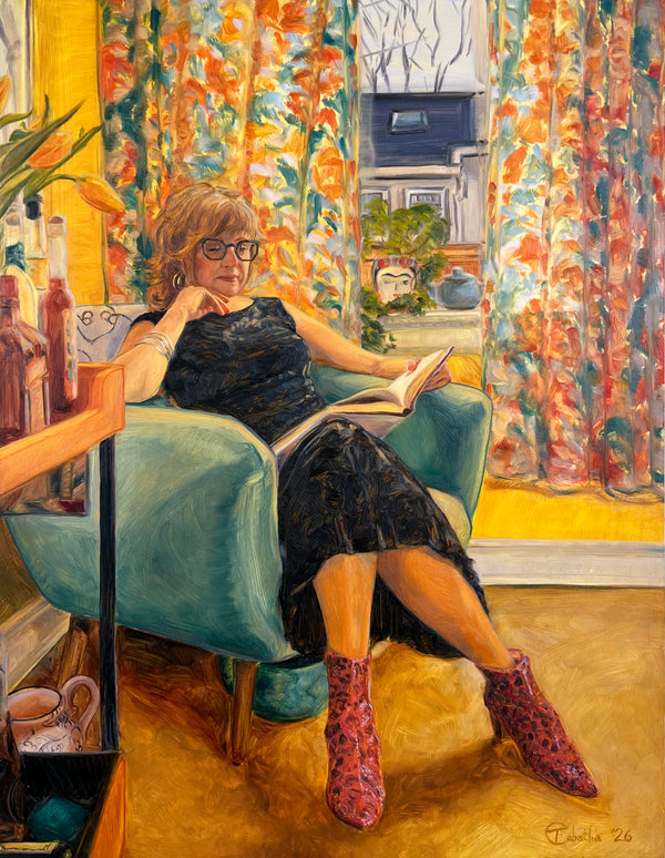 Woman sitting in a chair reading a book in a colorful room.