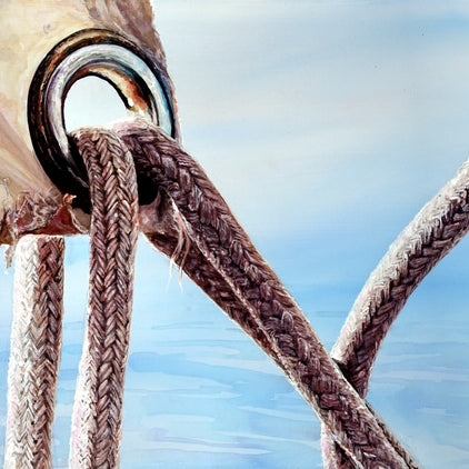 Close-up of a rope tied to a metal cleat with a blurred blue sky background